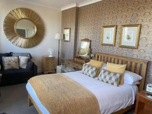大雅茅斯奈茨柯特酒店的一间卧室配有一张床、镜子和一张沙发