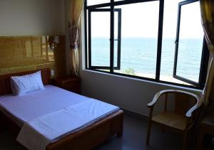 洞海Thăng Long Hotel的一间卧室设有一张床、一个窗口和一把椅子