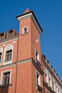 波兹南Palazzo Rosso Old Town的一座高大的砖砌建筑,上面有钟楼
