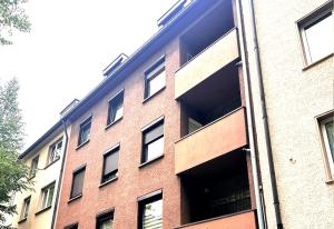 埃森# VAZ Apartments E01 Küche, TV, Netflix, ca 15 Min Messe u HBf的一座红砖建筑,有很多窗户