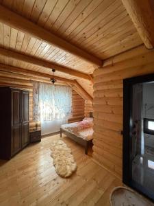 RozavleaCasa Ilies的小木屋内的卧室配有1张床和电视