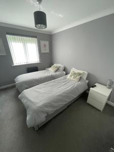 南安普敦Newly Refurbished Apartment with private parking的一间卧室设有两张床和窗户。