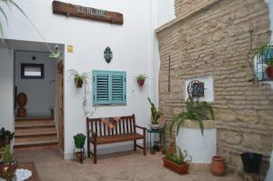 科尔多瓦Apartamentos El Aljibe Relax Tourist Cordoba的一个带长凳和砖墙的庭院