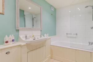 伊斯特布恩Tiger Inn - Grace的白色的浴室设有浴缸、水槽和浴缸。
