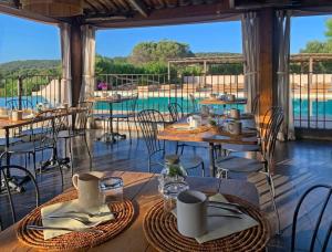 博尼法乔马奥拉别墅酒店的一间带桌椅的餐厅和一个游泳池