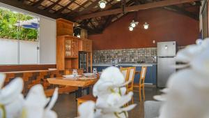 蒂拉登特斯Flat com Piscina no Centro de Tiradentes的厨房配有木桌、椅子和柜台。