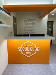 首尔Seoul Cube Jongro的橙色和白色的柜台,有南立方的酒店标志