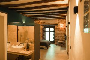 阿尔卡拉德荷那利斯Casa de los Mendoza - Casa Solariega en el casco histórico的一间带水槽的浴室和一张位于客房内的床
