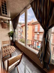 罗萨斯Amplio apartamento tranquilo cerca de la playa的阳台设有长凳和窗户。