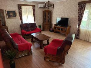 威尔帕扎Green House的客厅配有椅子、电视和桌子