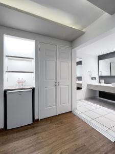 萨尔蒂约昆塔多拉达酒店&套房的厨房设有白色的墙壁和白色的冰箱。