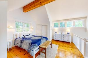 WestportPeriwinkle Cottage的白色卧室配有床和椅子