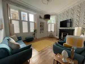 格拉斯哥Stunning West End Flat!的客厅配有2张蓝色沙发和壁炉