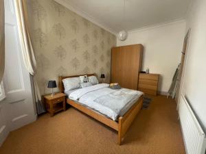 格拉斯哥Stunning West End Flat!的一间卧室设有一张大床和一个木制床头板