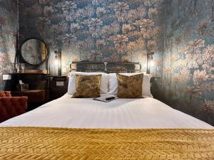 伊尔弗勒科姆The Devonshire Villa的卧室配有一张白色大床和花卉壁纸