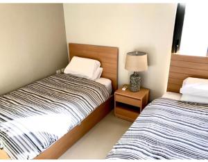 赫尔格达Emos Villa的一间卧室配有两张床和一个带灯的床头柜