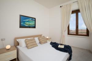 马达莱纳Old Charm - Seaview Apartment的卧室配有白色的床和窗户。
