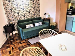 马林加Apto MILAO na Vila Paraíso, prático e relaxante的客厅配有绿色沙发和两把椅子