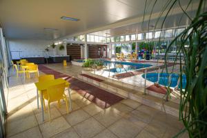 特玛斯德戴曼Apart Hotel Aguasol的一座游泳池,里面设有黄色的桌椅