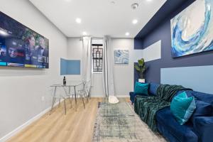 纽约SWJ G - Save on 2Day or more Stays 25min to Times Sq的客厅配有蓝色的沙发和桌子