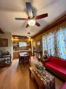 Manolo FortichDahilayan Comfy Cabin的客厅配有红色沙发和吊扇