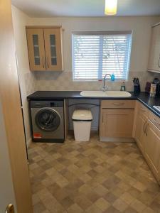 Redhill5 Holborn Spacious Home的厨房配有水槽和洗衣机