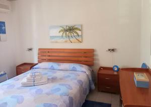 马斯卡利Blu Corallo的一间卧室配有一张带木制床头板的床