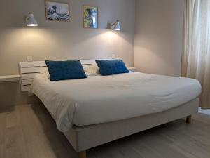 拉内斯泰尔Fuzei Hôtel Lorient-Lanester的一间卧室配有一张带蓝色枕头的大床
