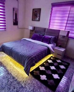 MakurduPeniel Place的一间卧室配有一张带紫色床单和紫色枕头的床