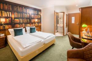 科赫姆哲迈尼尔酒店的一间卧室配有床、椅子和书架