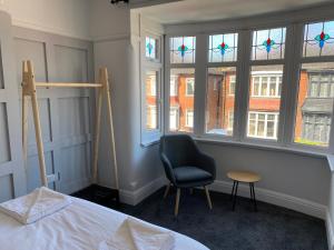 雷德卡Sandringham House的一间卧室配有一张床、一把椅子和窗户。