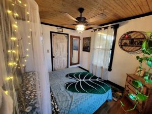 坦帕Cozy AF Jungle-House Hideaway的一间卧室配有一张床和吊扇