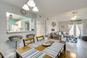 格尔夫海岸Gulf Shores Condo with Pool Access, 5 Mi to Beach!的用餐室以及带桌椅的起居室。