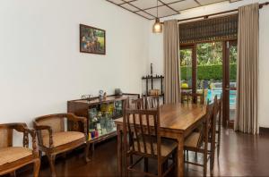 康提Surveyor's Residence Bungalow的一间带木桌和椅子的用餐室