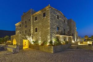 尼奥·奥伊蒂龙Itilo Traditional Hotel的一座大型石头建筑,晚上有灯