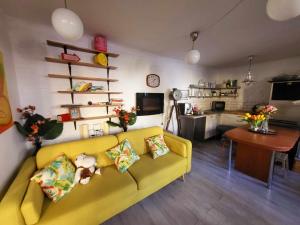 布达佩斯Cosy Apartman by the Castle的一间带黄色沙发的客厅和一间厨房