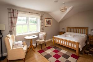 KilbrittainKilcatten Lodge的卧室配有床、椅子和窗户。