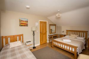 KilbrittainKilcatten Lodge的一间卧室配有两张床、一张桌子和一盏灯。