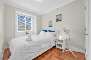 温哥华Luxurious Getaway in Vancouver-Private room with attached bathroom的白色的卧室设有白色的床和窗户。