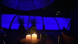 马克莱贝格Pool & Lake Holiday Home的一张桌子,上面有两根蜡烛和蓝色背景
