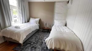 特隆赫姆Bo i historisk bygning, kort vei til sentrum的一间卧室设有两张单人床和一个窗户。