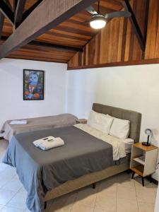 米格尔-佩雷拉Casa Rosada seu refúgio na serra的一间卧室设有一张床和木制天花板