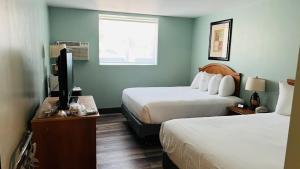 格伦伍德温泉Adventure Inn - Glenwood Springs的酒店客房设有两张床和一台平面电视。