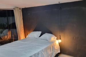 拉利伯塔德Hermosa Casa de Playa DejaBlue SV (con Mini Golf)的卧室内的一张带两个枕头的床