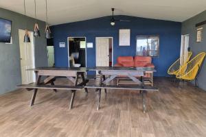 拉利伯塔德Hermosa Casa de Playa DejaBlue SV (con Mini Golf)的蓝色墙壁的房间,设有两张野餐桌