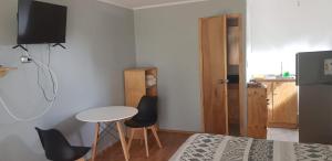 普琼卡维Strandvagen Maitencillo的小房间设有一张床、一张桌子和椅子