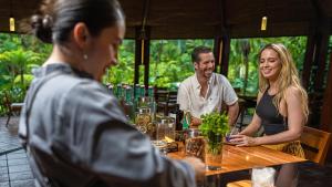福尔图纳塔巴康温泉Spa度假村的一群人坐在餐馆的桌子旁