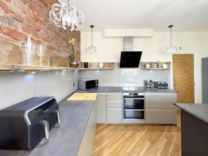 The Yorkshire Hosts - Knights Stay的厨房配有不锈钢用具和砖墙