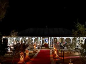 梅尔祖卡Sahara Majestic Luxury Camp的红地毯和夜间灯光的帐篷