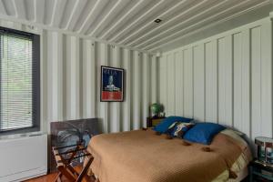 伊居利La Villa Joséphine的一间设有床铺的卧室,位于带条纹墙的房间内